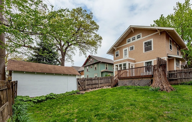 back of house featuring a yard, a deck, and a fenced backyard