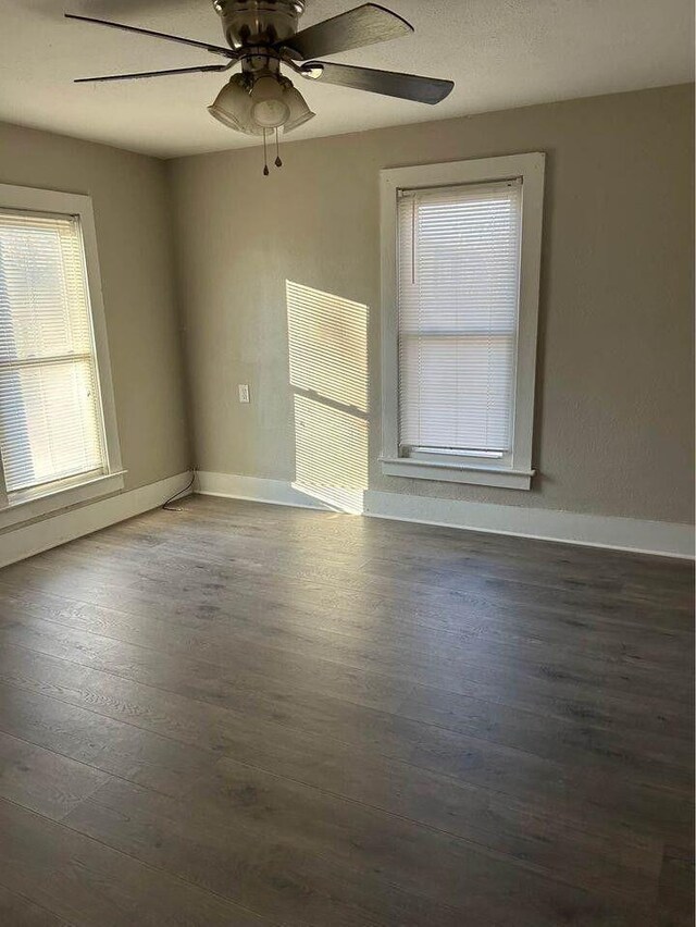 empty room with baseboards, ceiling fan, and wood finished floors