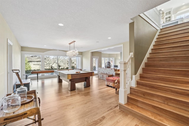 rec room with pool table, a textured ceiling, recessed lighting, and light wood-style flooring