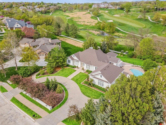 drone / aerial view featuring a water view, view of golf course, and a residential view
