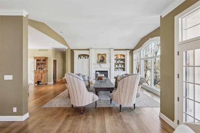 dining room with baseboards, lofted ceiling, visible vents, and a fireplace