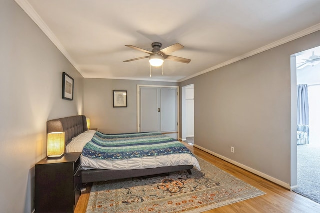 bedroom featuring baseboards, ornamental molding, a ceiling fan, and wood finished floors