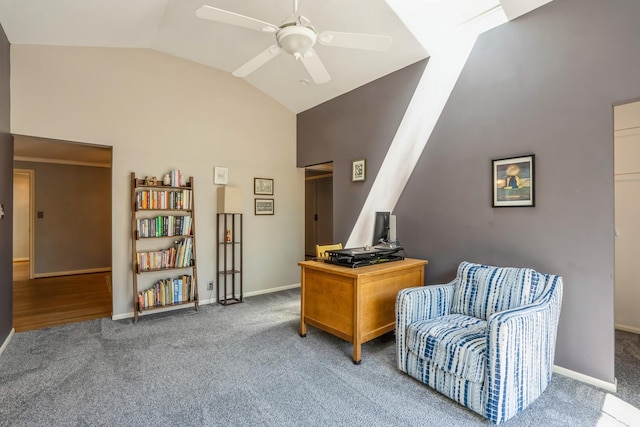 carpeted office space with ceiling fan, baseboards, and high vaulted ceiling