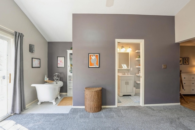 carpeted bedroom featuring connected bathroom, baseboards, multiple windows, and a sink