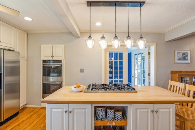 kitchen featuring white cabinets, light wood-style flooring, appliances with stainless steel finishes, wood counters, and decorative light fixtures