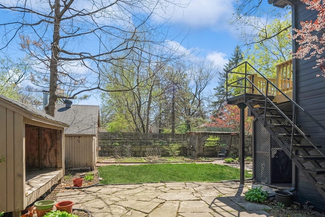 view of yard featuring a deck, a fenced backyard, and a patio area