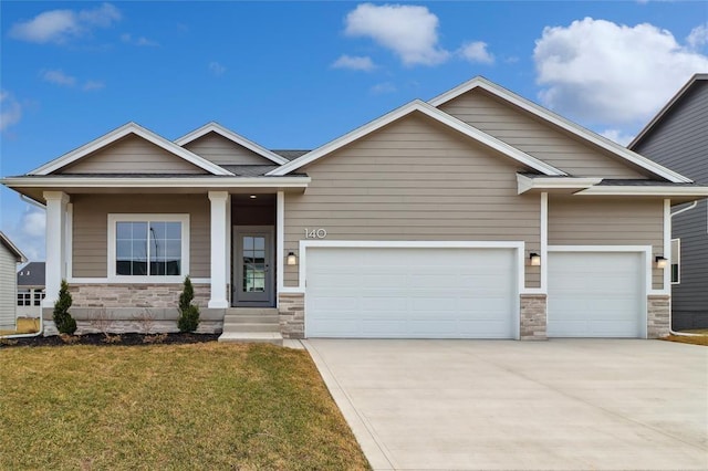 craftsman inspired home featuring an attached garage, concrete driveway, a front yard, and stone siding