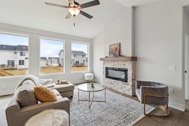 living room with a fireplace, high vaulted ceiling, a ceiling fan, baseboards, and wood finished floors