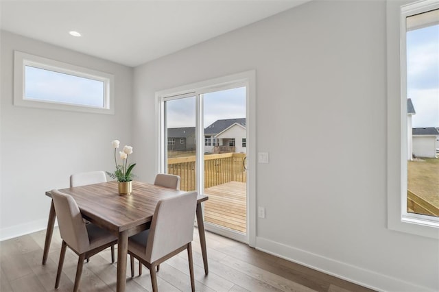 dining area with baseboards, recessed lighting, wood finished floors, and a healthy amount of sunlight