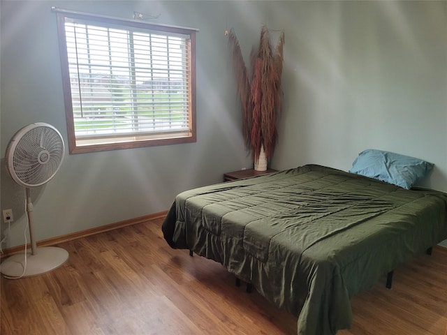 bedroom with baseboards and wood finished floors