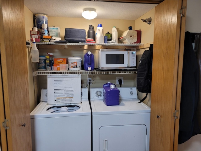 laundry area featuring laundry area, a textured ceiling, and washing machine and clothes dryer