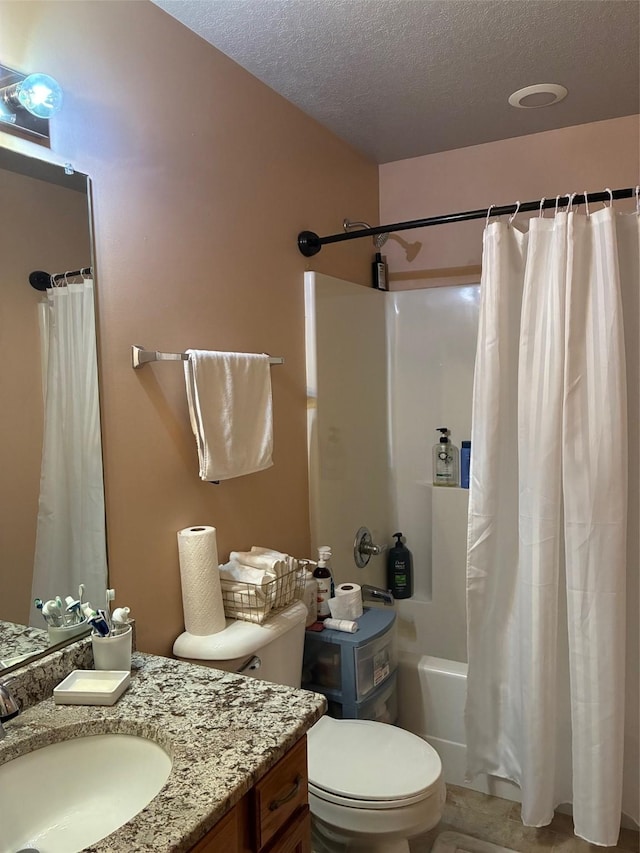 full bathroom featuring vanity, a textured ceiling, shower / bathtub combination with curtain, and toilet