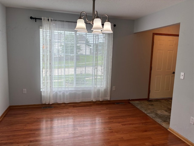108 S 46th St, West Des Moines, IA 50265 - empty room with plenty of natural light, wood finished floors, a chandelier, and baseboards