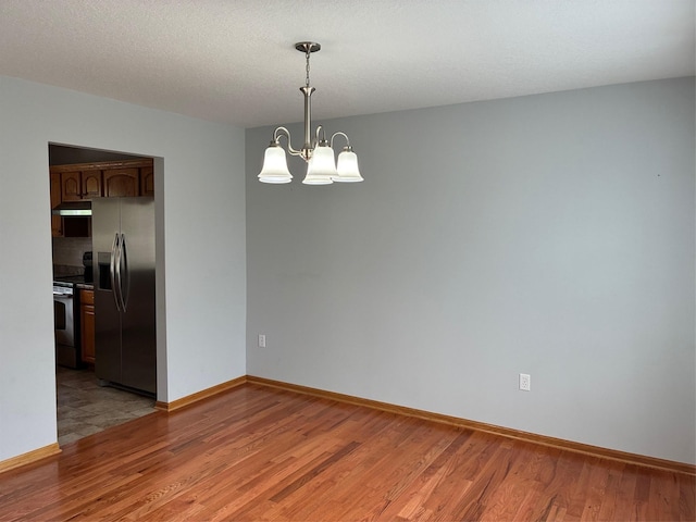 108 S 46th St, West Des Moines, IA 50265 - spare room with light wood-style floors, a chandelier, and baseboards