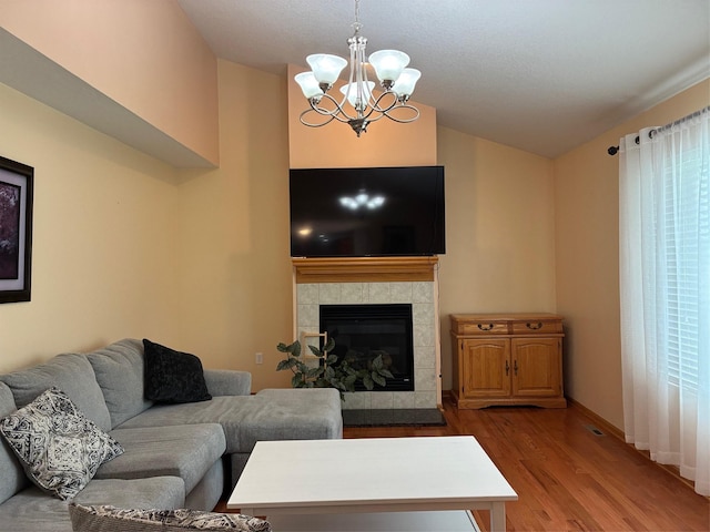 108 S 46th St, West Des Moines, IA 50265 - living room featuring wood finished floors, a chandelier, vaulted ceiling, a fireplace, and baseboards
