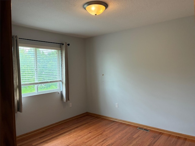 108 S 46th St, West Des Moines, IA 50265 - empty room featuring light wood-style flooring, baseboards, and a textured ceiling