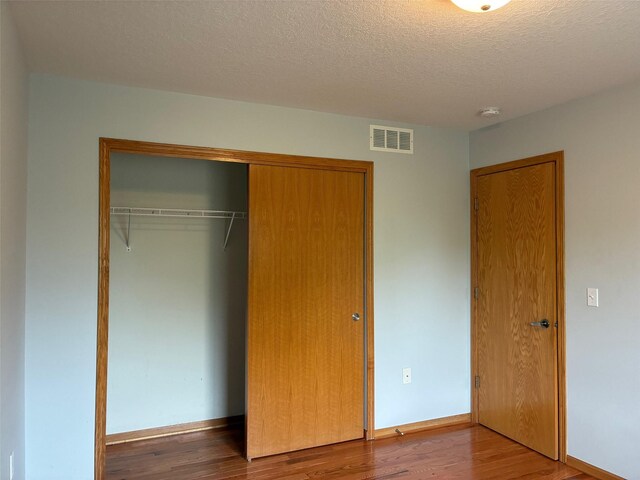 108 S 46th St, West Des Moines, IA 50265 - unfurnished bedroom with a closet, wood finished floors, a textured ceiling, and baseboards