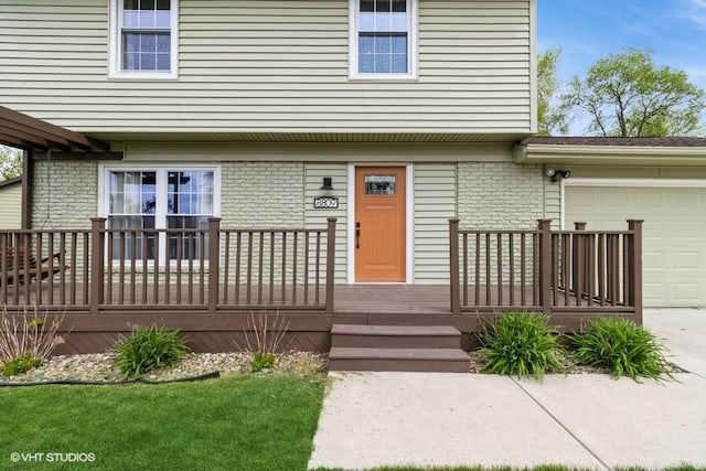 property entrance featuring an attached garage, brick siding, and concrete driveway