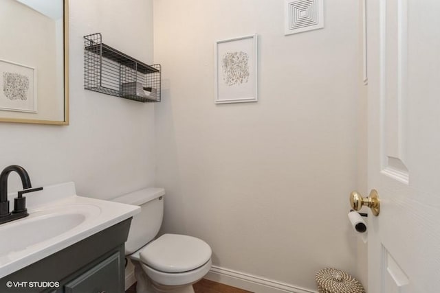 bathroom with visible vents, baseboards, toilet, and vanity