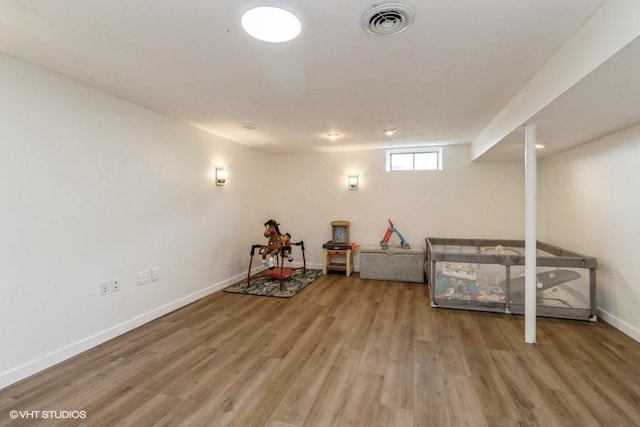 basement with baseboards, visible vents, and wood finished floors