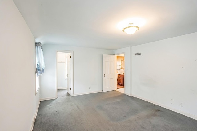 unfurnished bedroom featuring carpet flooring, baseboards, visible vents, and connected bathroom