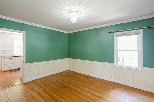 348 49th St, Des Moines, IA 50312 - unfurnished room with a chandelier, wood finished floors, wainscoting, and ornamental molding