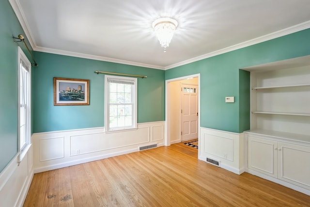 348 49th St, Des Moines, IA 50312 - empty room with wainscoting, crown molding, light wood-style floors, a chandelier, and a decorative wall