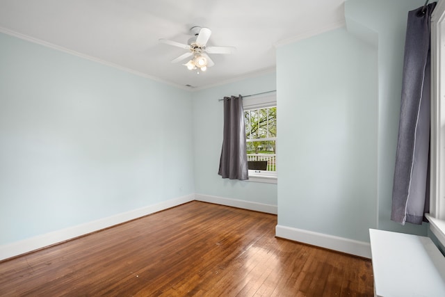 spare room with baseboards, ornamental molding, wood-type flooring, and a ceiling fan