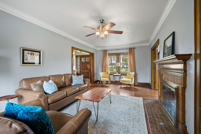living room featuring a ceiling fan, dark wood-style flooring, crown molding, a fireplace with flush hearth, and baseboards