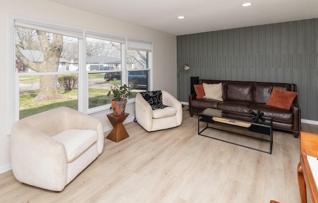 living area featuring wood finished floors, recessed lighting, baseboards, and an accent wall