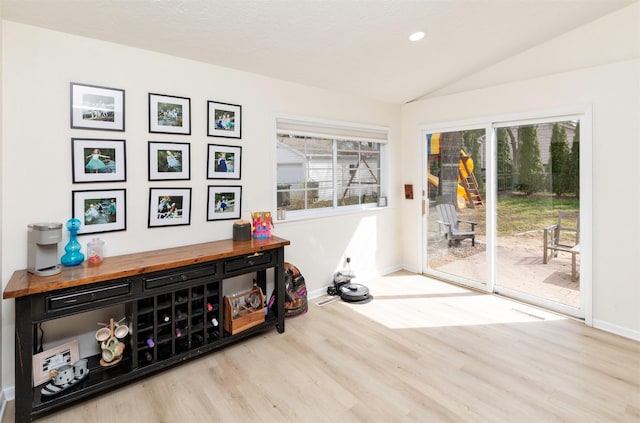 doorway with recessed lighting, baseboards, wood finished floors, and lofted ceiling