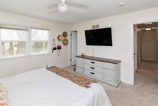 bedroom featuring baseboards, light carpet, a ceiling fan, and visible vents