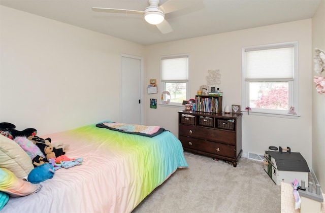 bedroom featuring visible vents, ceiling fan, and light colored carpet