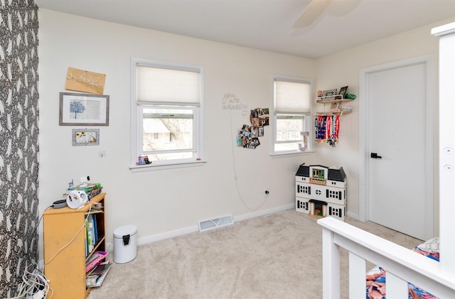 interior space with baseboards, carpet, a ceiling fan, and visible vents