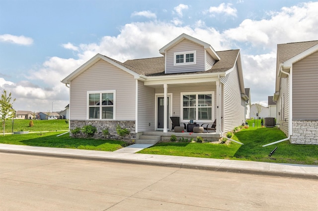 2601 NW 30th Ln, Ankeny, IA 50023 - view of front of house featuring covered porch, stone siding, central AC unit, and a front yard