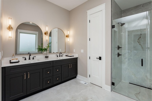 full bath with a sink, baseboards, and a stall shower