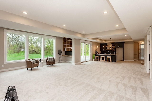living area featuring baseboards, light carpet, and recessed lighting