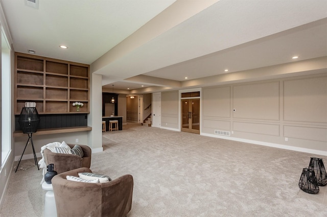 sitting room with carpet floors, visible vents, built in features, and stairway