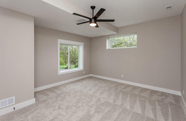 carpeted empty room featuring visible vents, baseboards, and ceiling fan