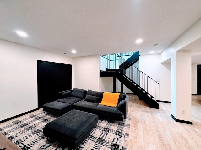 living room featuring baseboards, recessed lighting, wood finished floors, and stairway