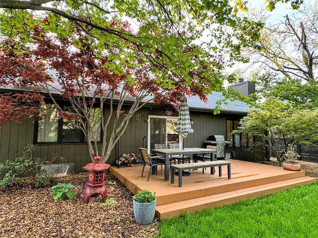 deck featuring outdoor dining space and a grill
