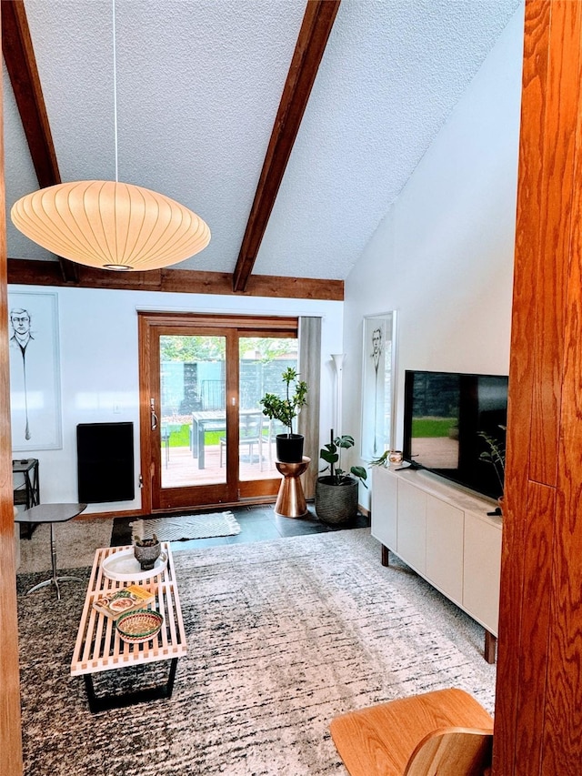living area with beam ceiling and a textured ceiling