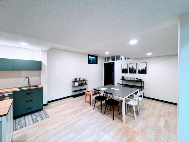 dining space with light wood-style floors, baseboards, recessed lighting, and a textured ceiling