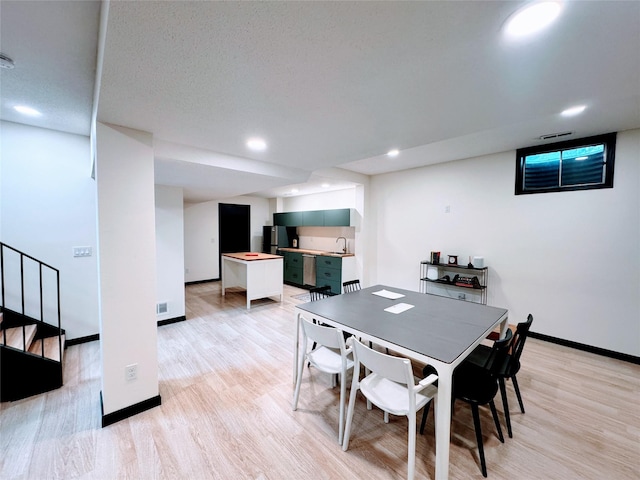dining room with recessed lighting, baseboards, and light wood-style floors