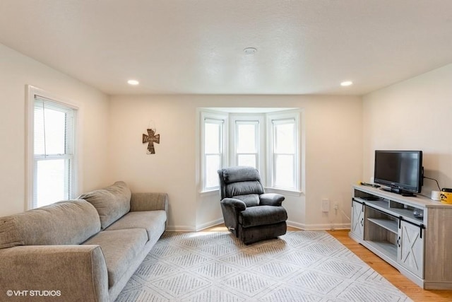 living room with plenty of natural light, recessed lighting, and light wood-style flooring