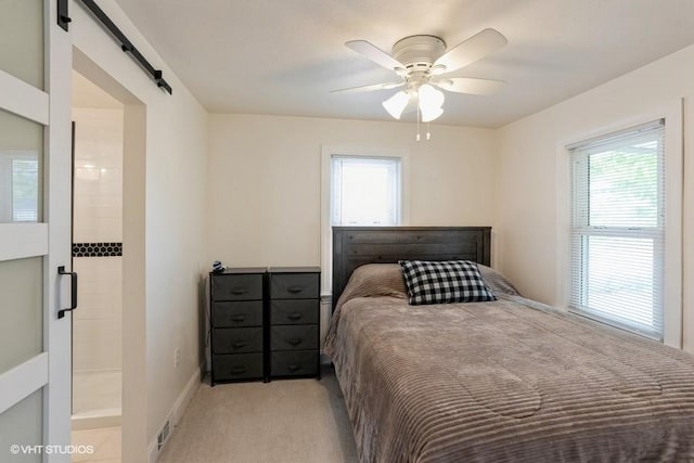 bedroom with a barn door, visible vents, multiple windows, and light carpet