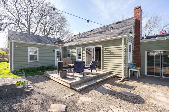 back of house featuring a chimney and a deck