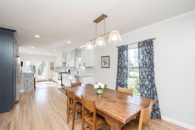 dining room with recessed lighting, baseboards, and light wood-type flooring