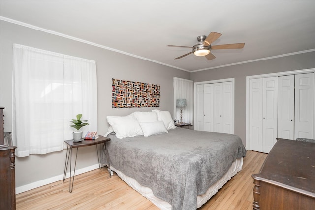 bedroom with a ceiling fan, baseboards, two closets, ornamental molding, and light wood-style flooring
