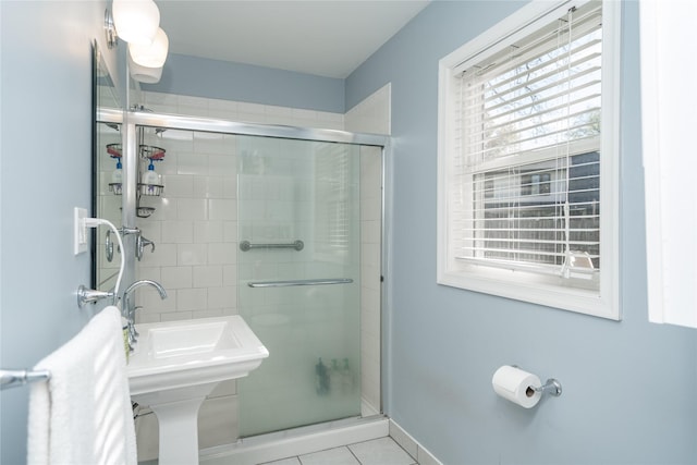 bathroom with baseboards, tile patterned flooring, and a shower stall